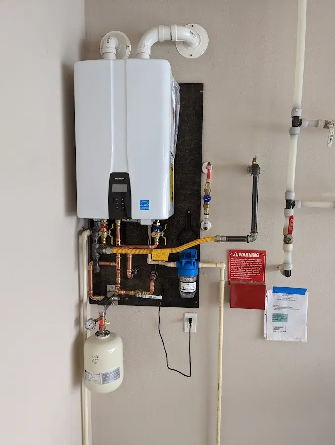Professional plumber installing copper piping in a Putney home